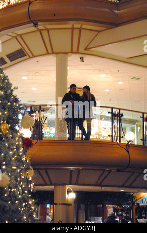 Young Couple Leaning on Railing at  Princes Square Shopping Centre, Glasgow.Scotland. Christmas Eve, December