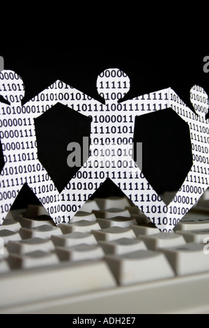 paper dolls with binary numbers on keyboard symbolic of knowledge workers in the information technology industry Stock Photo