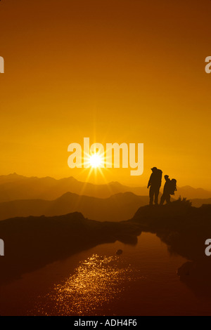 Hikers Watch Sunset From Ridge Douglas Is SE AK Summer Silhouette Stock Photo