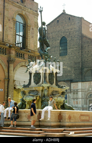 Bologna Italy; tourists lounge on the Fontana del Nettuno Fountain of Neptune, Piazza Nettuno Stock Photo