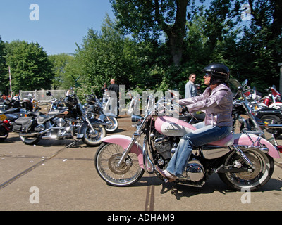 Lady biker on a custom built pink with white Barbie-doll style Harley Davidson motorcycle Breda the Netherlands Stock Photo