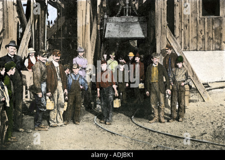 Coal miners emerging from the mine shaft after their nine hours of toil are ended in the early 1900s. Hand-colored halftone of a photograph Stock Photo