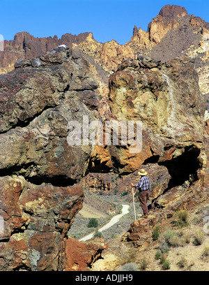 Hiker viewing road in Leslie Gulch through rock arch Oregon Stock Photo