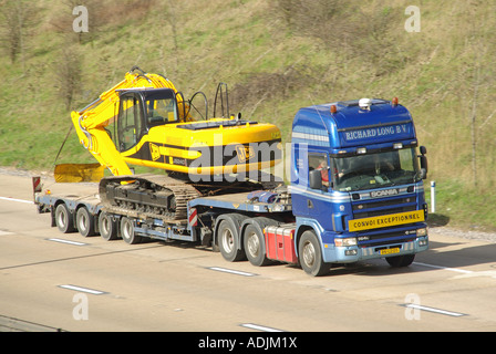 Netherlands NL country code on Scania 164L 480 lorry truck & low loader trailer JCB JS240 excavator wide load CONVOI EXCEPTIONNEL on UK motorway road Stock Photo