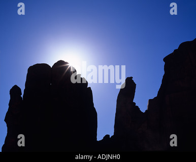 Sunburst over rock formation Monument Valley AZ Stock Photo