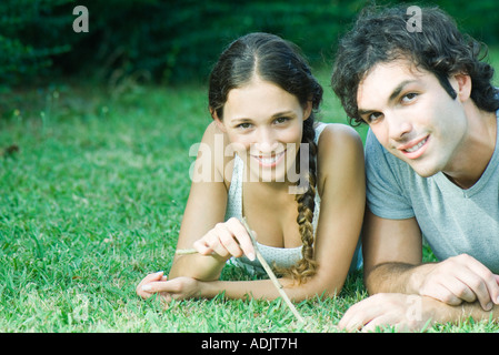 Couple lying in grass together Stock Photo