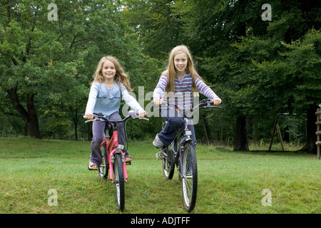 Two girls riding bicycles in the Forest of Dean UK Stock Photo