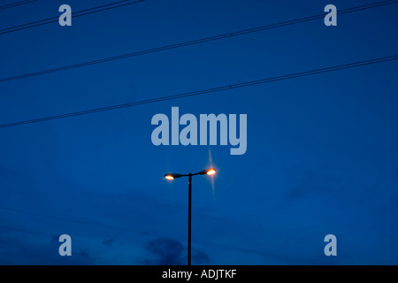 Urban street lamp at dusk with electricity lines cables Stock Photo