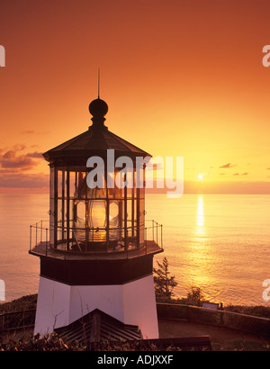 Cape Meares Lighthouse with sunset reflected on water Oregon Stock Photo