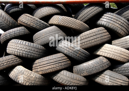 Worn out car tyres at a scrapyard wait to be shredded and recycled Stock Photo