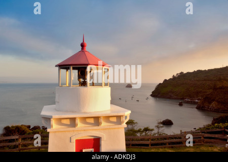 Trinidad Lighthouse with boats in harbor and sunset California Stock Photo