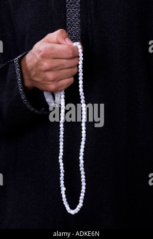 Man praying beads Stock Photo
