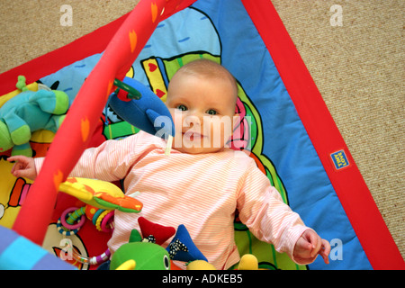 Baby Girl lying on play mat Stock Photo