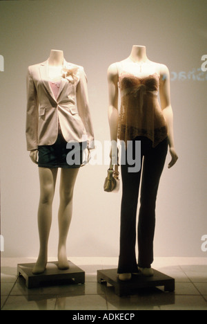 two woman female fashion mannequinns in shop boutique display window wearing mini skirt jacket top trousers elegant skinny Stock Photo