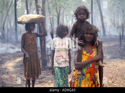 Aboriginal women return from gathering bushtucker after a seasonal burn-off bushfire Arnhemland Northern territory Australia Stock Photo