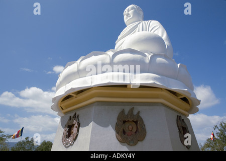 Statue of [Sakyamuni Buddha] seated on a lotus at 'Long Son Pagoda', showing medallion heads of monks memorialized here. Stock Photo