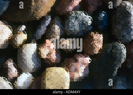 A colorful, textured abstract of sunlit river rocks in a garden path. Stock Photo