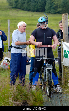 Competitor in annual World Mountain Bike Bog Snorkelling Championships at Llanwrtyd Wells Powys UK organiser Gordon Greene left Stock Photo