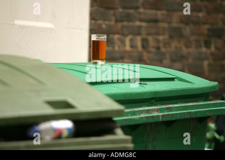 alone pint of beer forget me not thirsty quenching glass rubbish bin waste throwaway trash bins litter typical rubbish cleaning Stock Photo