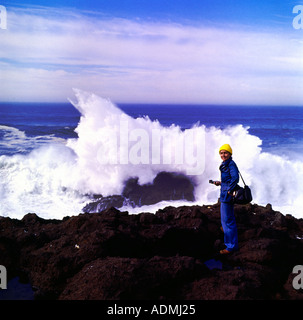 Photographer viewing huge surf crashing on offshore rocks on the Oregon coast Stock Photo