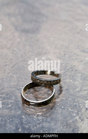 Bride and groom s wedding rings lying on table Stock Photo