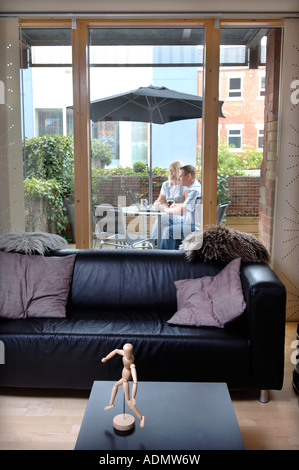 A COUPLE USING A LAPTOP ON THE BALCONY AREA OF A CONTEMPORARY STUDIO FLAT UK 2007 Stock Photo