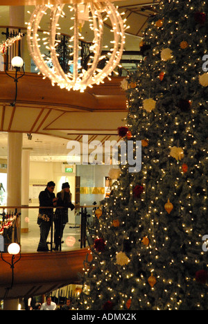 Young Couple Leaning over Rail at the   Princes Square Shopping Centre, Glasgow.Scotland.  December