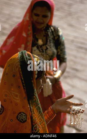 India Jaiselmer traditionally dressed women selling bracelets on street Stock Photo