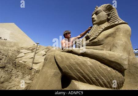 Sand Sculptor Pavel Barishev from Russia carves an Egyptian Pharoh out of sand at Black Rock on Brighton Beach Stock Photo