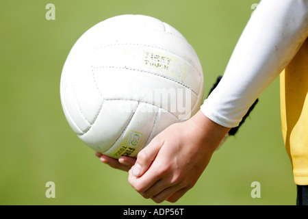 teenage boy demonstrates traditional way of hand passing the football during gaelic football game Stock Photo