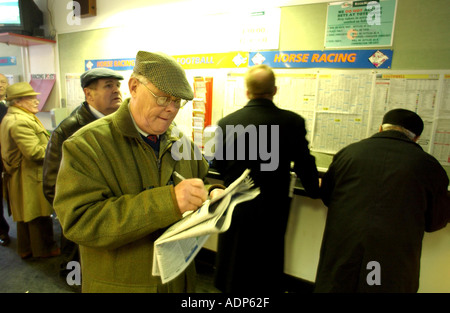 A racegoer marking his card in the Tote betting shop at the all weather racecourse at Lingfield Sussex UK Stock Photo