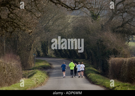 Joggers keeping fit out jogging in country lane Bourton on the Water The Cotswolds United Kingdom Stock Photo