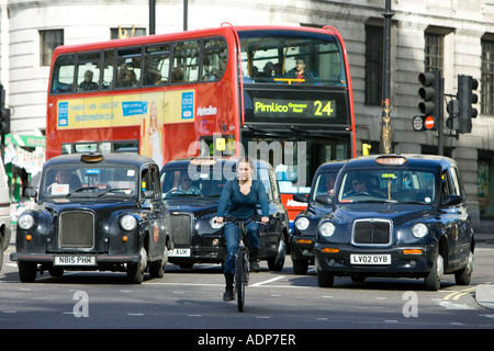 Biker in front of heavy traffic in Trafalgar Square downtown London city centre England United Kingdom Stock Photo