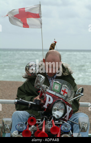 Man in Mod clothing sitting on scooter at bike convention in Brighton England Stock Photo