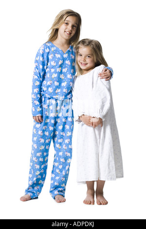 Two girls in pajamas hugging and smiling Stock Photo