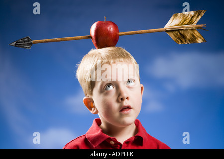 Boy with apple and arrow on head Stock Photo