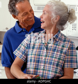 Senior Caucasian couple preparing meal in home kitchen Stock Photo