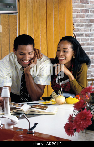 African American couple making recipe from cookbook Stock Photo
