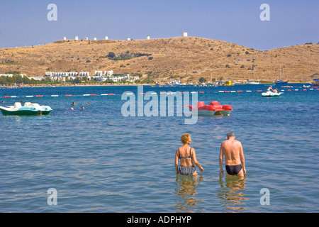 Elderly couple standing in the waters of Gumbet Beach in Turkey Stock Photo