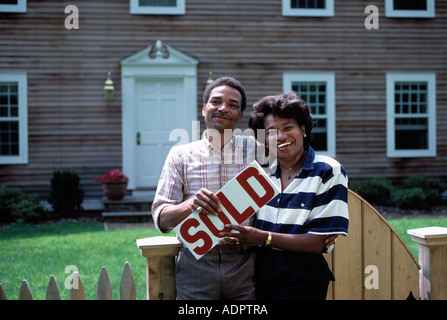African American couple pose in front of their new home Stock Photo