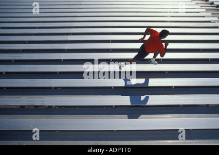 Determined African American man running on bleachers Stock Photo