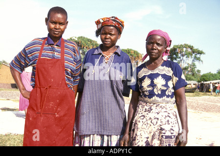 Three Luo women pose for a photograph in a break from spreading fish in the sun to dry Stock Photo