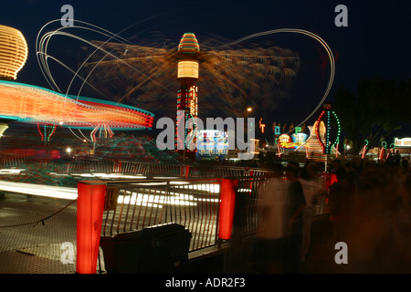 Carnival Rides Ride named Twister at near left Ride named Hurricane at center  Stock Photo