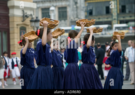 Young Basque girls dressed in blue perform a traditional Basque folk dance with baskets Plaza Arriaga Bilbao Stock Photo