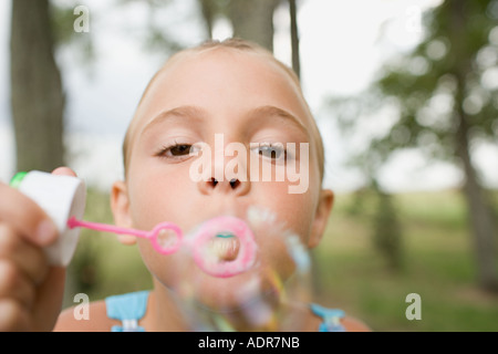 Girl using a bubble wand Stock Photo
