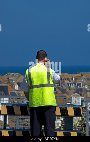 a man wearing a reflective coat using a mobile phone Stock Photo