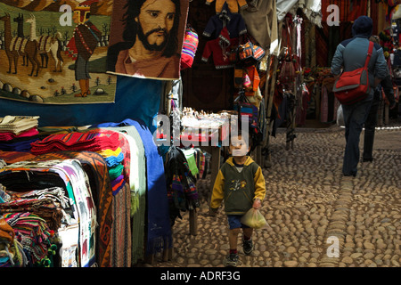 [Pisac Market], [Sacred Valley], Peru, 'South America', young boy shopping and colourful market stall selling peruvian textiles Stock Photo