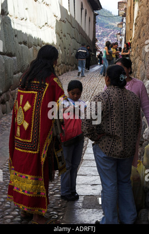 Native Quechua Indian wearing colourful ceremonial costume by [Palace of Inca Roca], [Calle Hatunrumiyoc], Cusco, Peru, Andes Stock Photo
