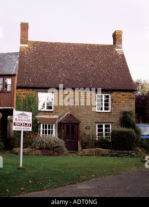 Sold sign in front of traditional country cottage Stock Photo