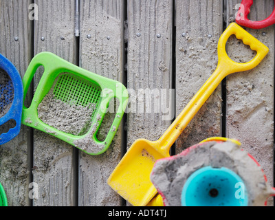 Sand pit toys lying on wooden deck, view from above Stock Photo